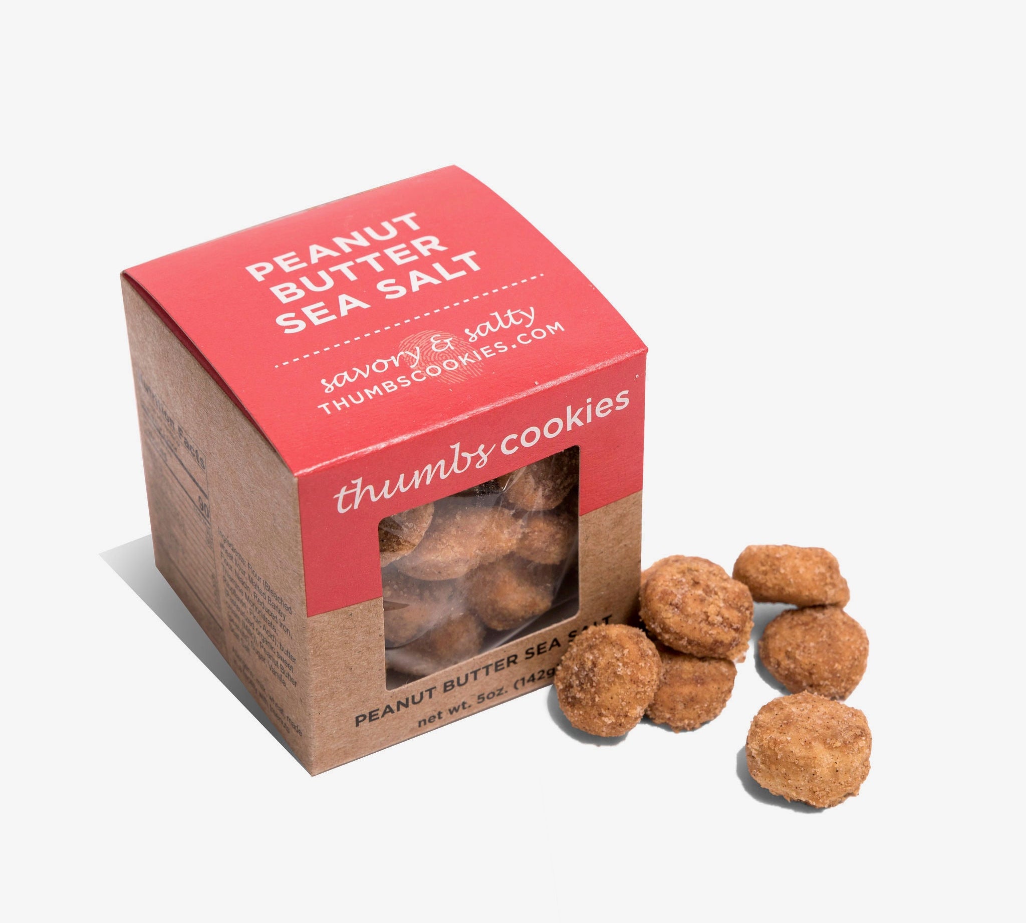 A box labeled "Thumbs Cookies" with peanut butter sea salt flavor is shown next to a small pile of golden cookies, lightly dusted with sea salt. The net weight is 5 oz (142g).